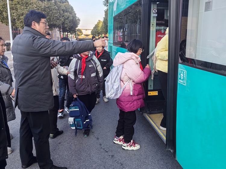 新洋第二实验学校祝校长引导学生上车.jpg